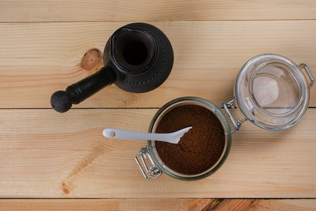 Ground coffee in a glass jar and cezve. View from above.