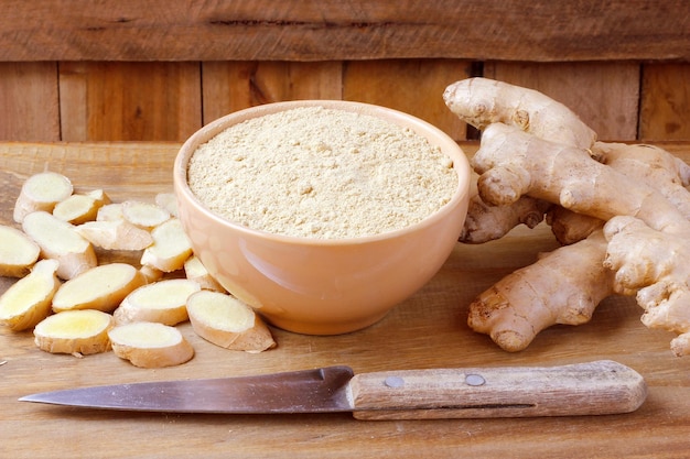 Ground ginger powder in ceramic bowl over rustic wooden table Antiinflammatory and antioxidant