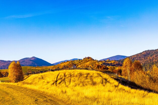 Ground road stretches in highland against giant mountains