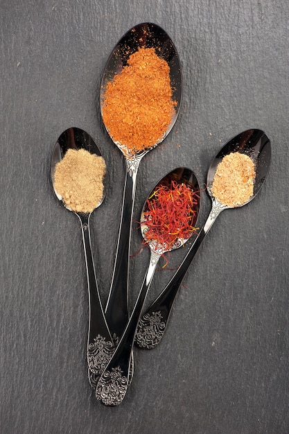 Ground spices in black spoon Spicy Top view