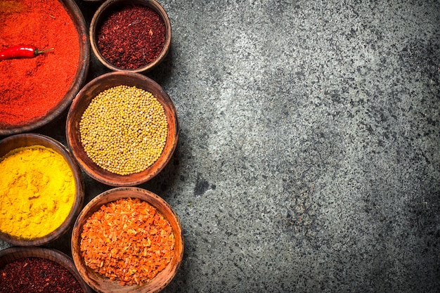 Ground spices in bowls on rustic table.