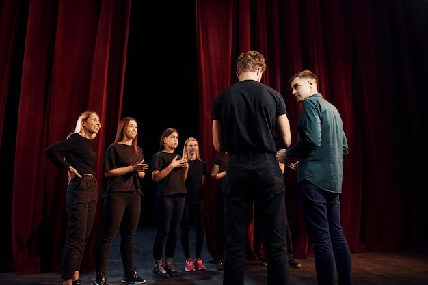 Group of actors in dark colored clothes on rehearsal in the theater