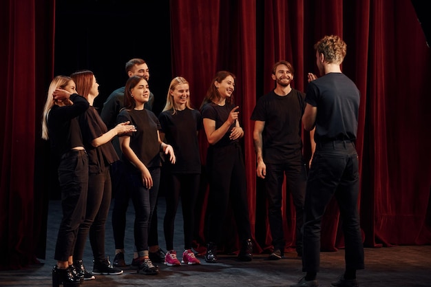 Group of actors in dark colored clothes on rehearsal in the theater