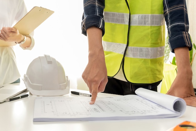 Group of architect and engineer construction worker planning and analysing on blueprint in meeting room office at construction site building, industrial, construction contract and contractor concept