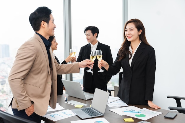 Group of Asian business people holding glasses of wine to celebrate new year