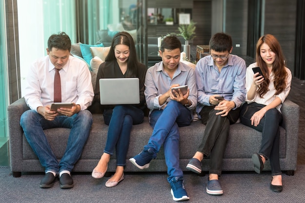 Group Of Asian Business people using the technology device working