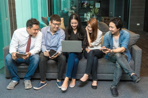 Group Of Asian Business people with casual suit using the technology mobile