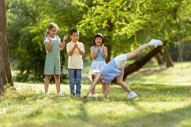 Group of asian and caucasian kids having fun in the park