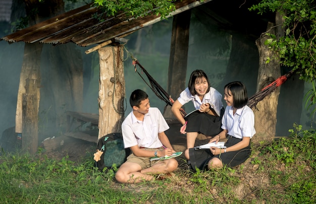 Group of Asian students in uniform studying together at outdoor.