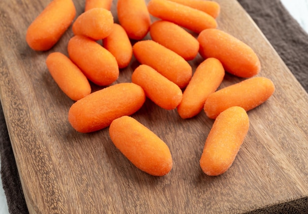 A group of baby carrots over a wooden board