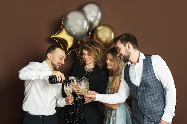 Group of beautiful well dressed party people celebrating  holiday or event and drinking sparkling wine