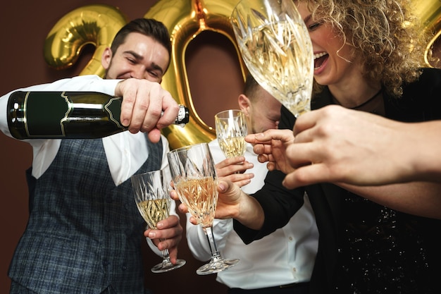 Group of beautiful well dressed party people celebrating  New Year and drinking sparkling wine