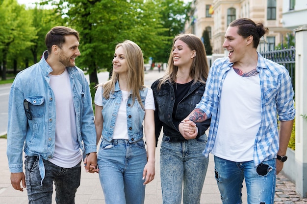 Group of best friends are having in a city park. Young people happy to see each other during a meeting.