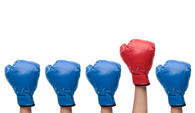 Group of blue boxing gloves with a red one standing out