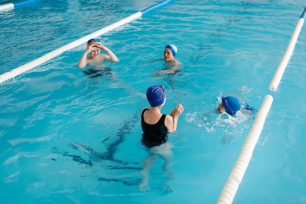 A group of boys and girls play and learn to swim in a modern swimming pool Development of children's sports Healthy parenting and promotion of children's sports