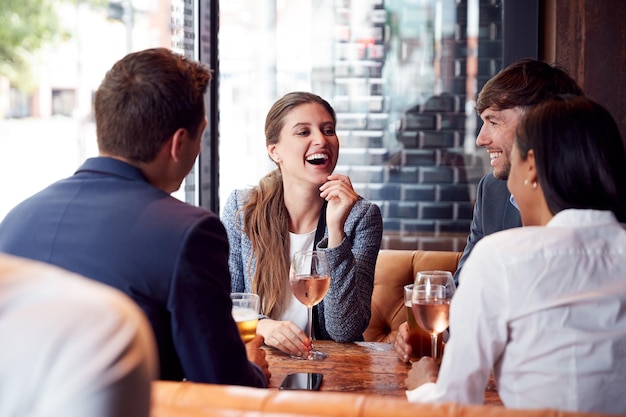 Group Of Business Colleagues Meeting For Drinks And Socializing In Bar After Work