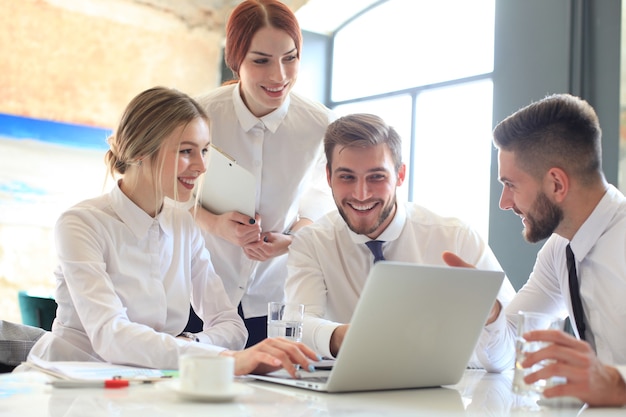 Group of business partners discussing ideas and planning work in office.