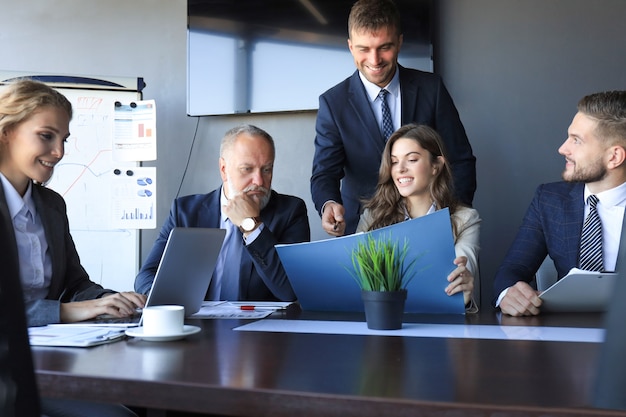 Group of business partners discussing ideas and planning work in office.