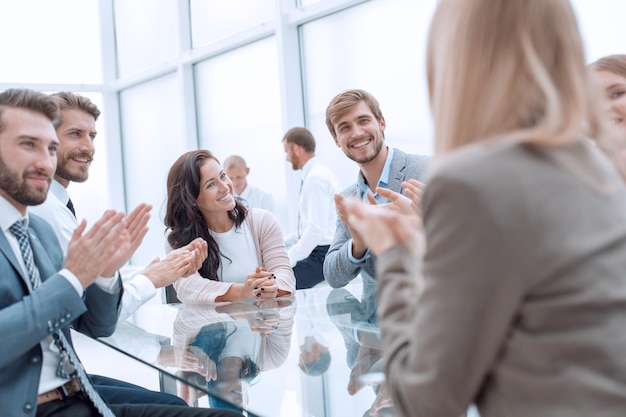 Group of business people applauding sitting at the negotiating table