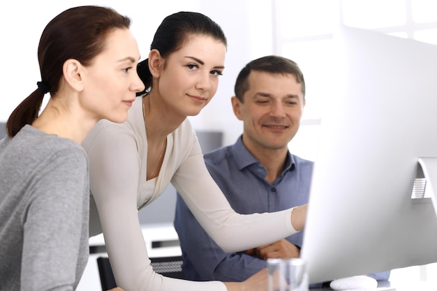 Group of business people discussing questions at meeting in modern office. Headshot at negotiation or workplace. Teamwork, partnership and business concept.