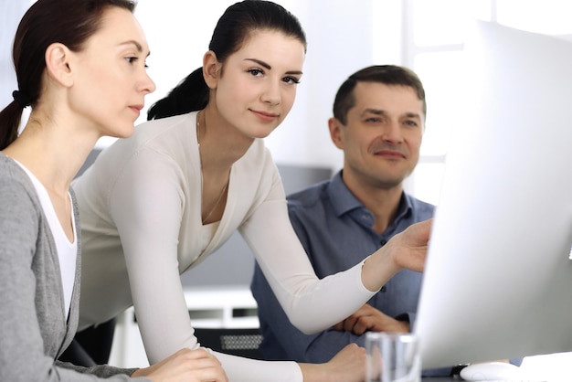 Group of business people discussing questions at meeting in modern office. Headshot at negotiation or workplace. Teamwork, partnership and business concept.