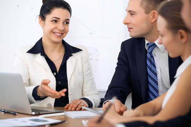 Group of business people and lawyers discussing contract papers at meeting.