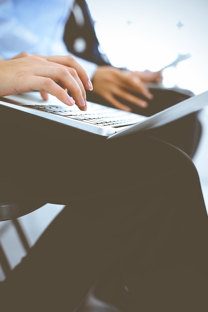 Group of business people working in office, close-up. Businesswoman working with laptop. Conference or training concepts.