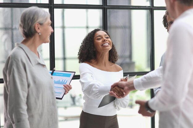 Group of business workers standing together shaking hands at the office