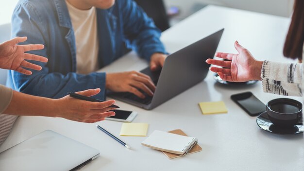 Group of businessman discussing and working on laptop computer together in office