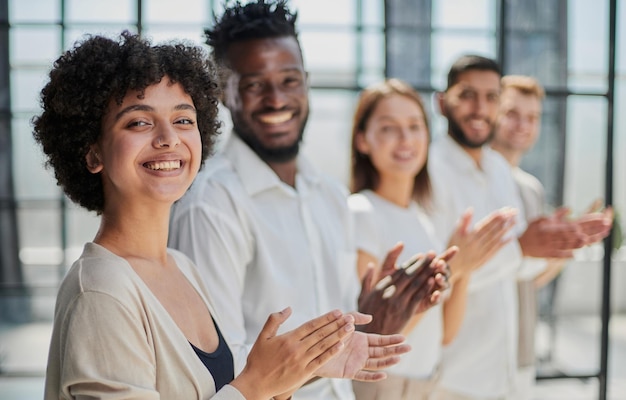 Group of businesspeople sitting in a line and applauding