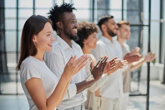 Group of businesspeople sitting in a line and applauding