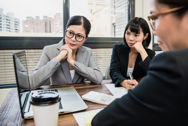 group of businesswomen concentrated staring at the laptop and thinking new ways to solve problems