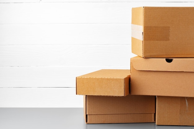 Group of cardboard boxes against white wooden wall