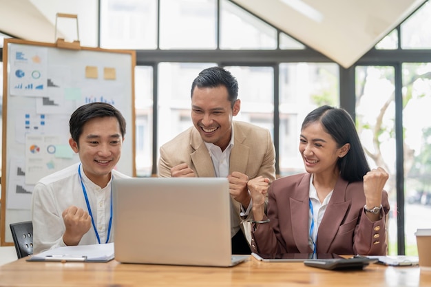 A group of cheerful Asian businesspeople are celebrating their project success together