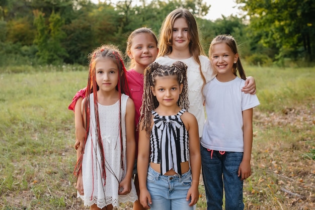 A group of cheerful girls are smiling and playing in the Park during sunset