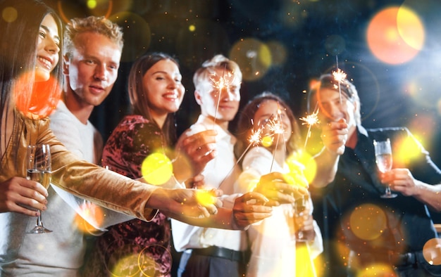 Group of cheerful young people have party and celebrating new year indoors