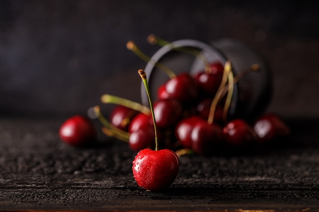 Group of cherry on a dark wood table. Juicy fresh cherry berries. Close up of a group of fruit