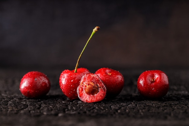 Group of cherry on a dark wood table. Juicy fresh cherry berries. Close up of a group of fruit