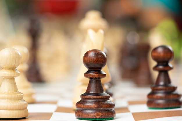 Group of chess pieces on the portable board. Playing in the park concept. Family rest or leisure with friends. Outdoor activity.