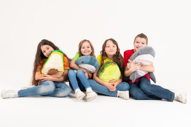 A group of children in bright clothes with their favorite soft toys. World children s day.