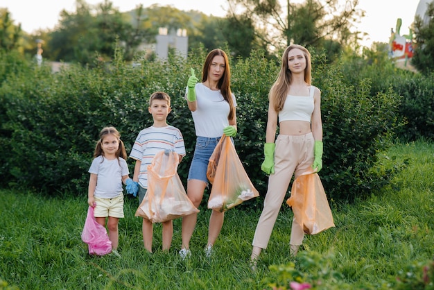 A group of children with their parents are engaged in garbage collection.

