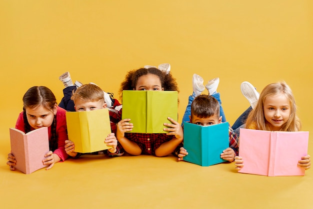 Group of childrens covering their faces with books