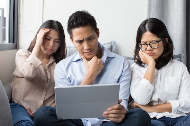 Group of colleague looking at digital tablet with disappointment