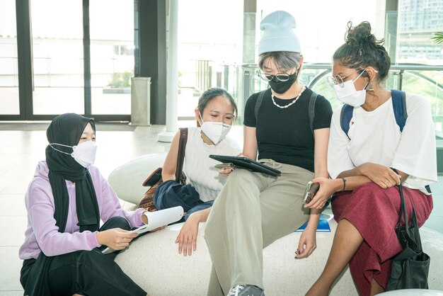 Group of college students meeting while looking at tablet together