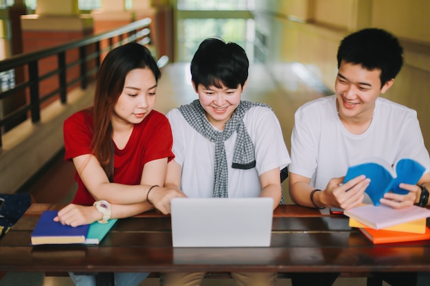  Group of college students read books together on the table 