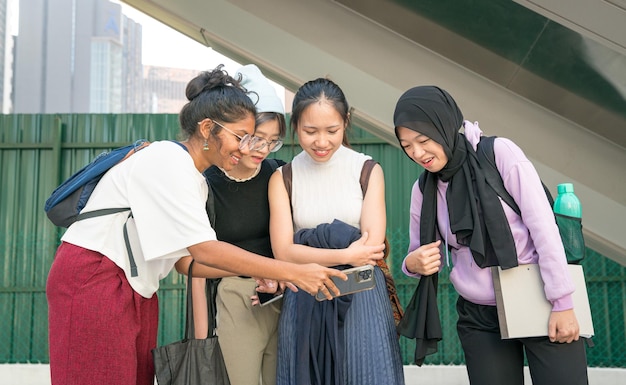 Group of college students smiling and watching content on smartphone together