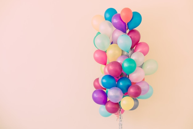 Group of colorful balloons on pastel color background.