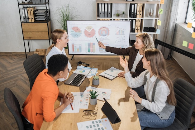 Group of competent female financiers having working meeting at office