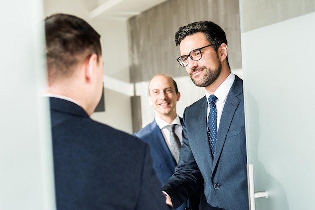 Group of confident business people greeting with a handshake at business meeting in modern office or closing the deal agreement by shaking hands