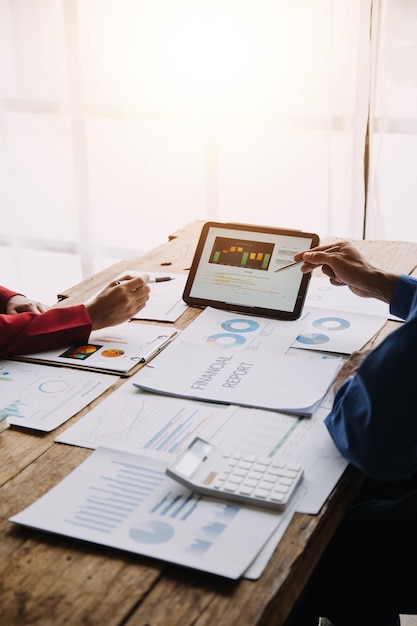 Group of confident business people point to graphs and charts to analyze market data balance sheet account net profit to plan new sales strategies to increase production capacity